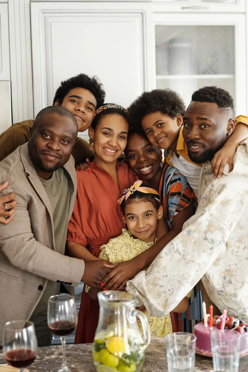 A big family squeezed together in a group hug in the kitchen